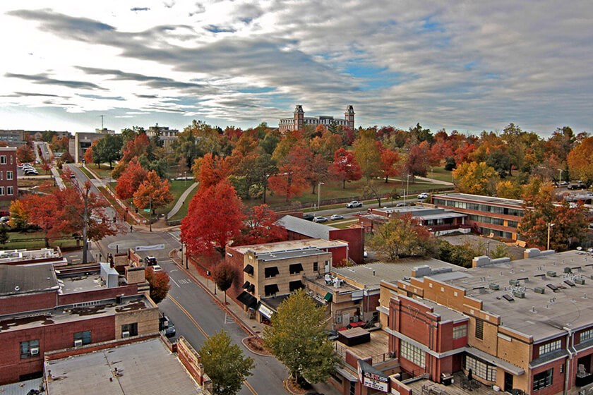A city in the state of Arkansas featuring fall trees and buildings, that will pay you to move there.