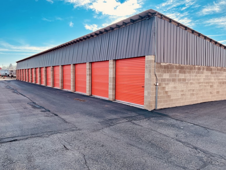 Outdoor climate-controlled storage units for rent with orange doors.