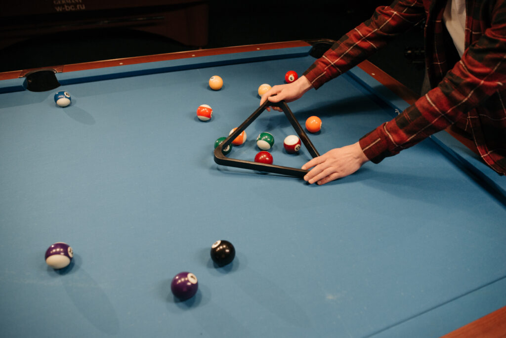 Photo of a person s hands setting up their pool table