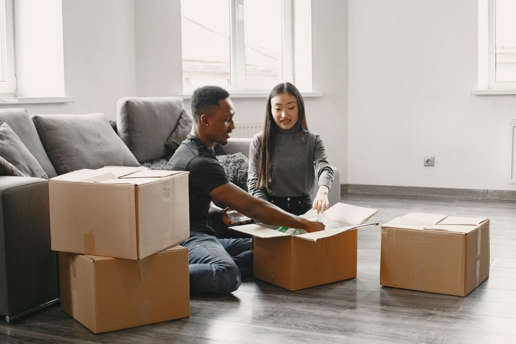 Man and woman sitting near moving boxes
