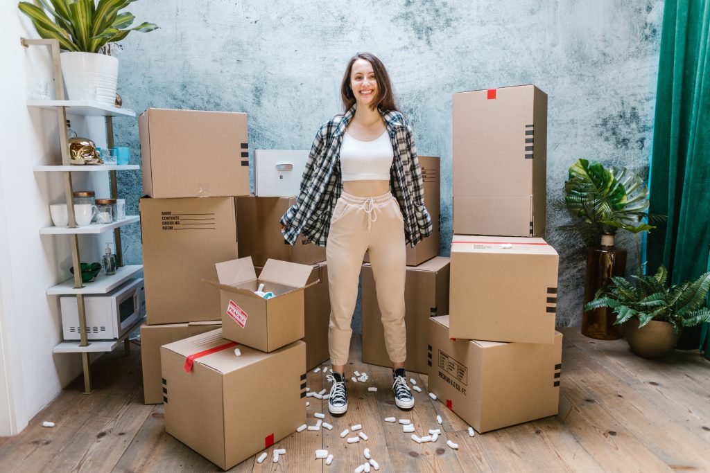 Woman celebrating moving surrounded by boxes