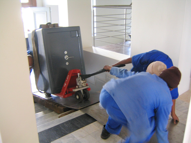 A team moving a heavy safe up stairs