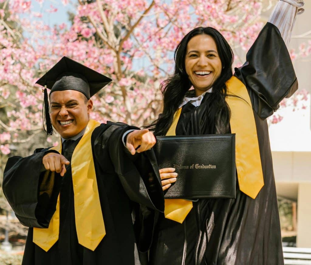 Two students wearing graduation robes