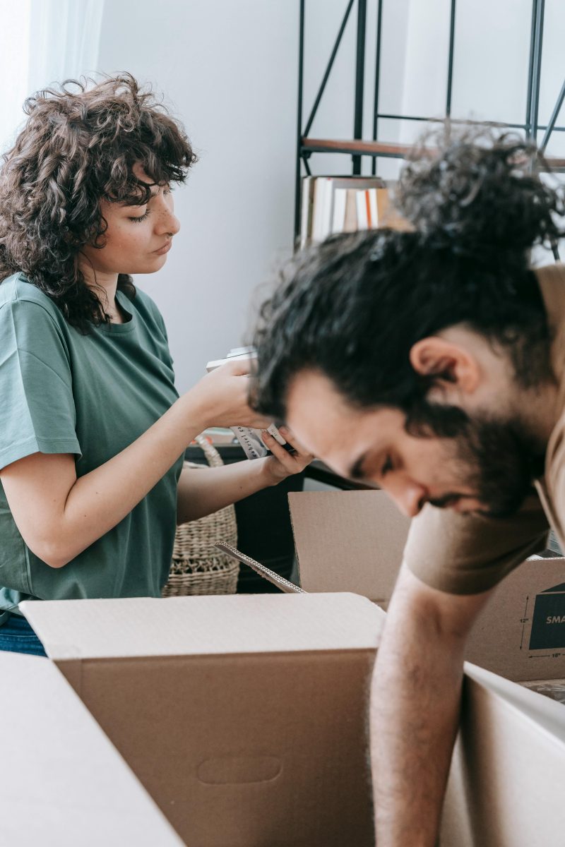 Woman packing for a move while a man looks inside a box