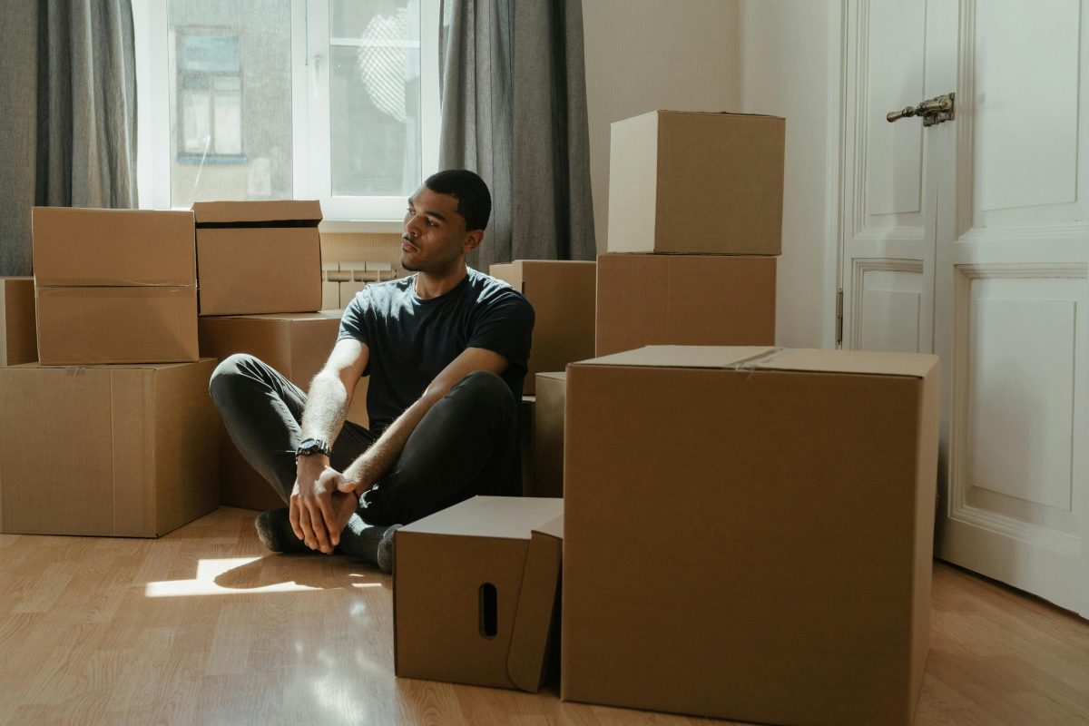 Man meditating surrounded by cardboard box