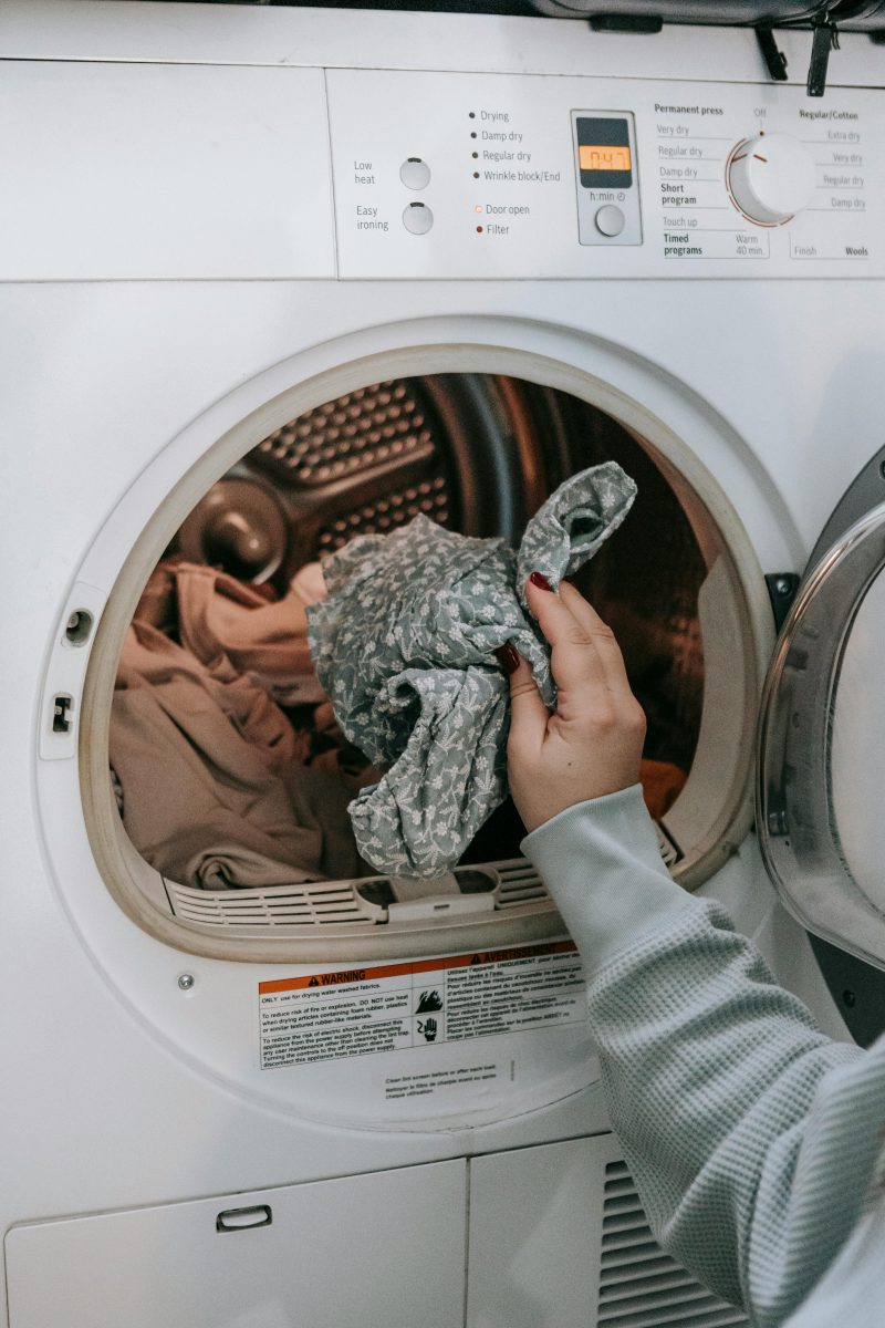 Woman putting clothes in washing machine