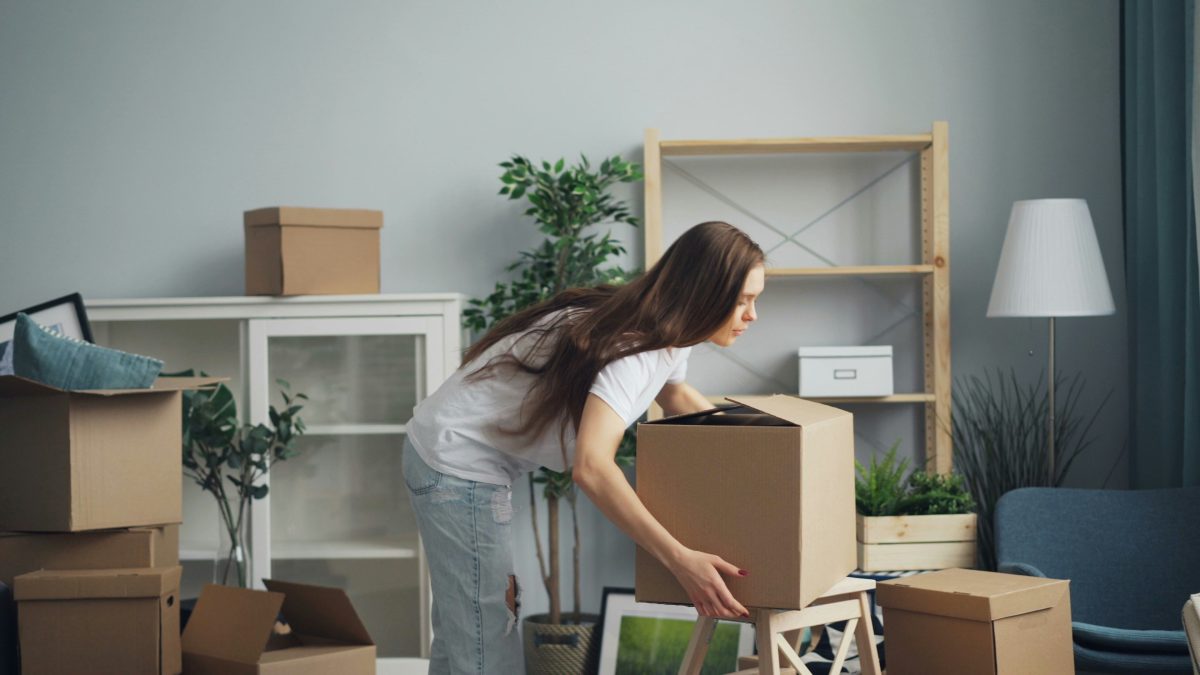 Woman packing belongings into a moving box