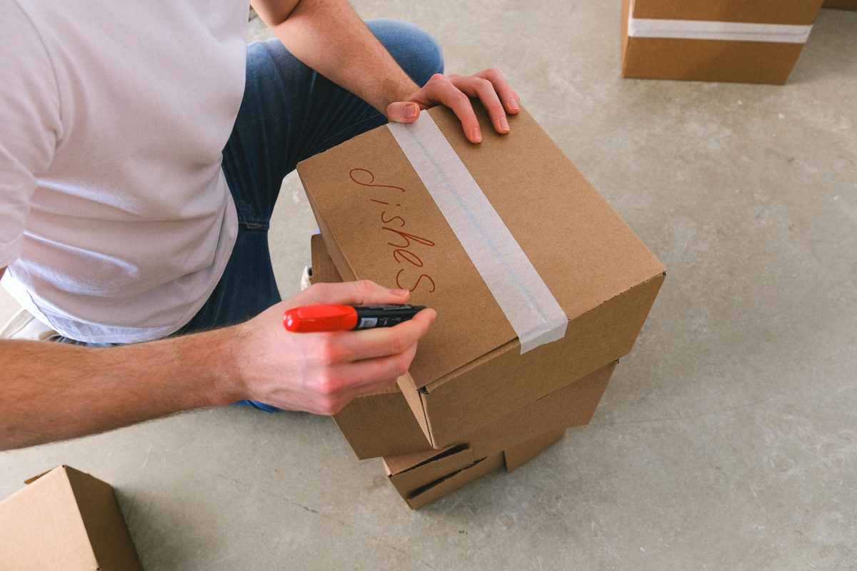 Man writing labels on moving box
