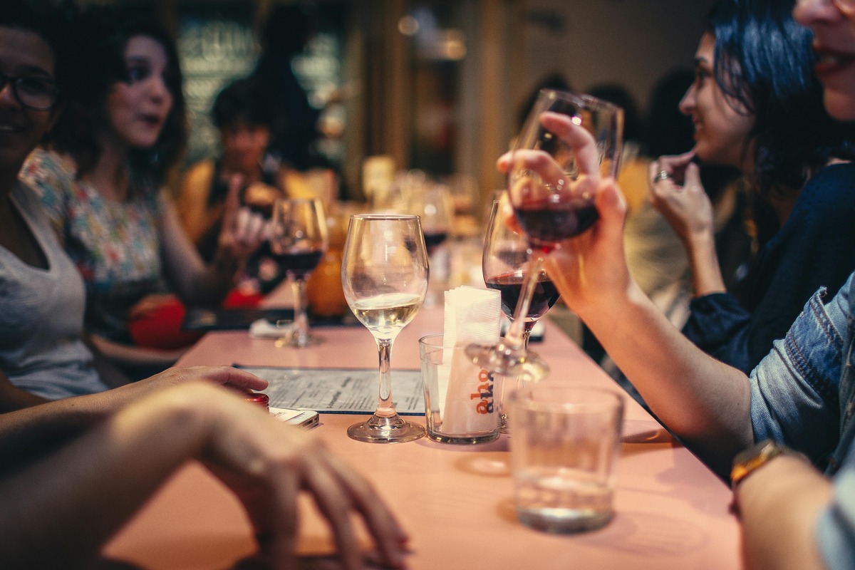 A group of people in a bar drinking wine