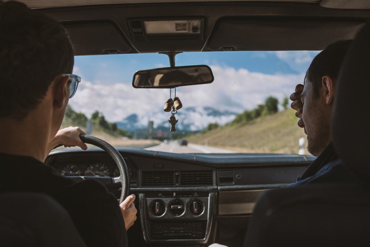 Two people driving down a long stretch of road