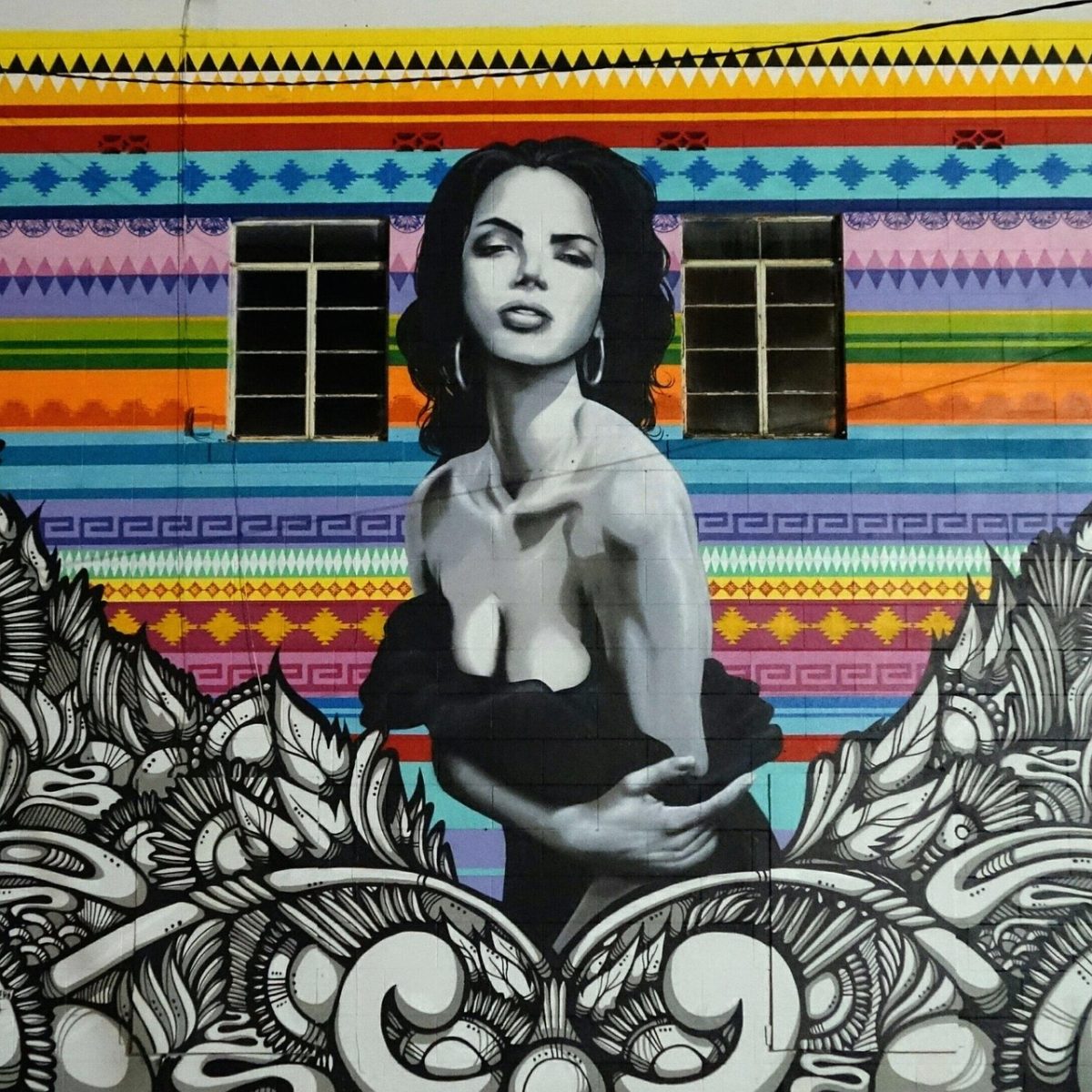 Street art in San Antonio, depicting a woman in black and white over a colorful backdrop