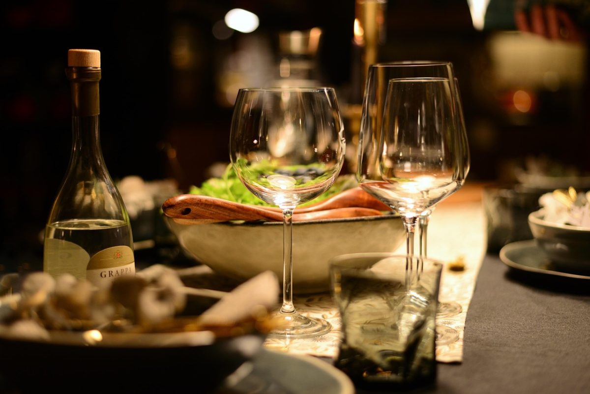 A dinner and wine glasses in a dimly-lit fine dining restaurant
