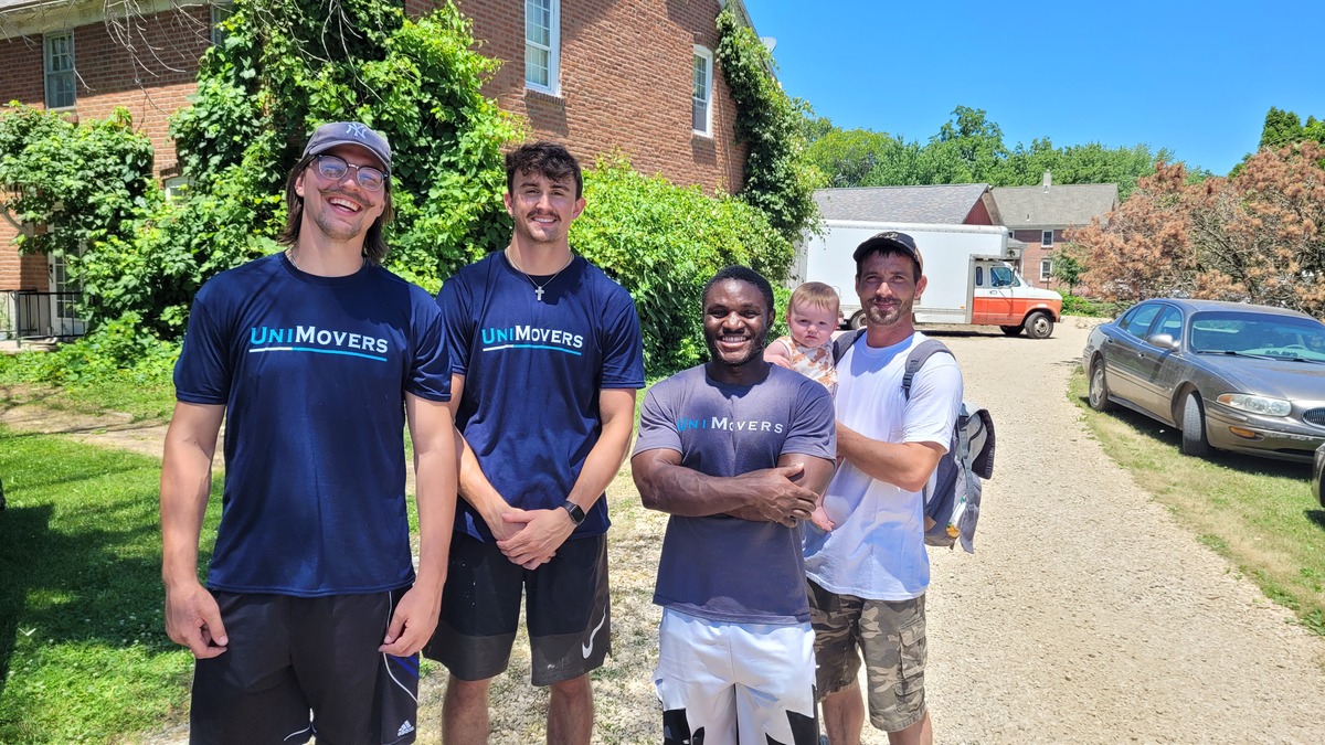 A group of movers working smiling with a customer