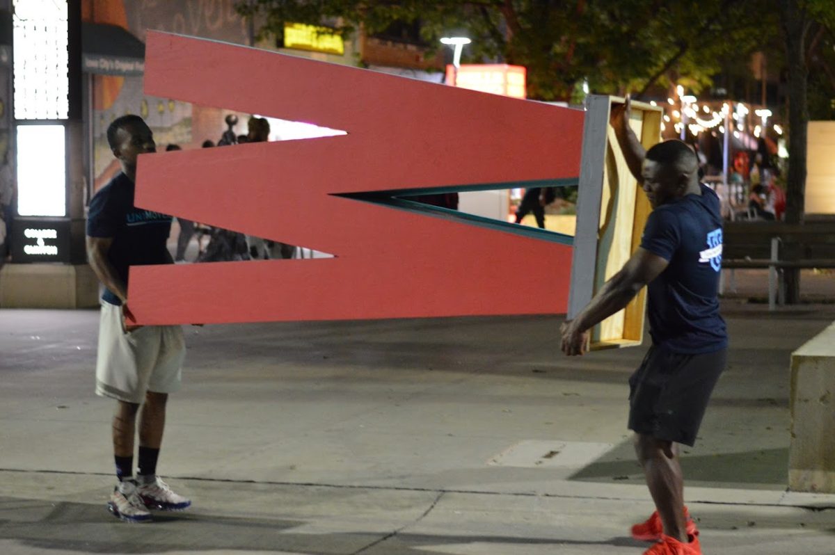 Two movers moving an awkwardly-shaped W item