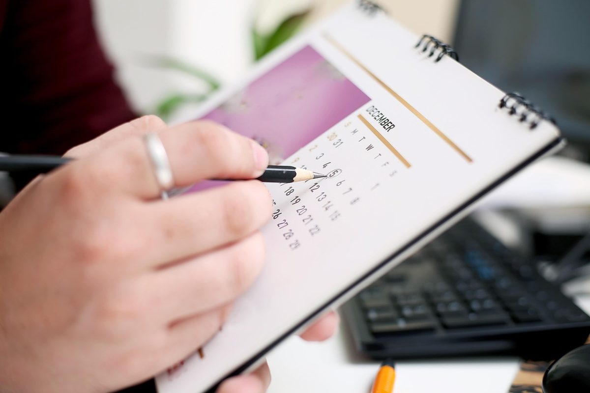 A close-up on a hand marking a calendar