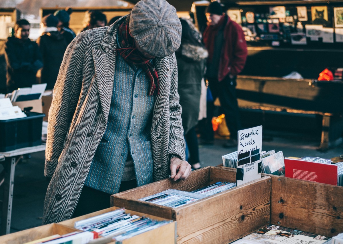 A man browsing a box of records at an estate sale