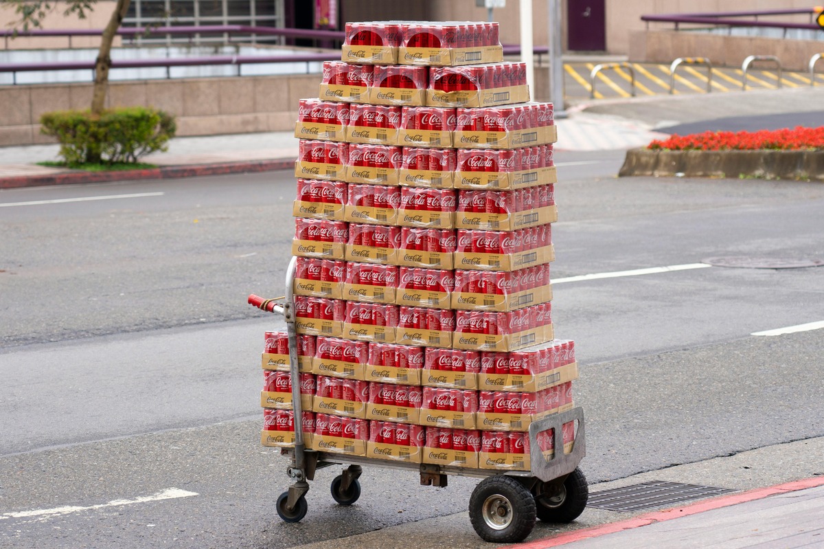 A hand truck with crates of soda