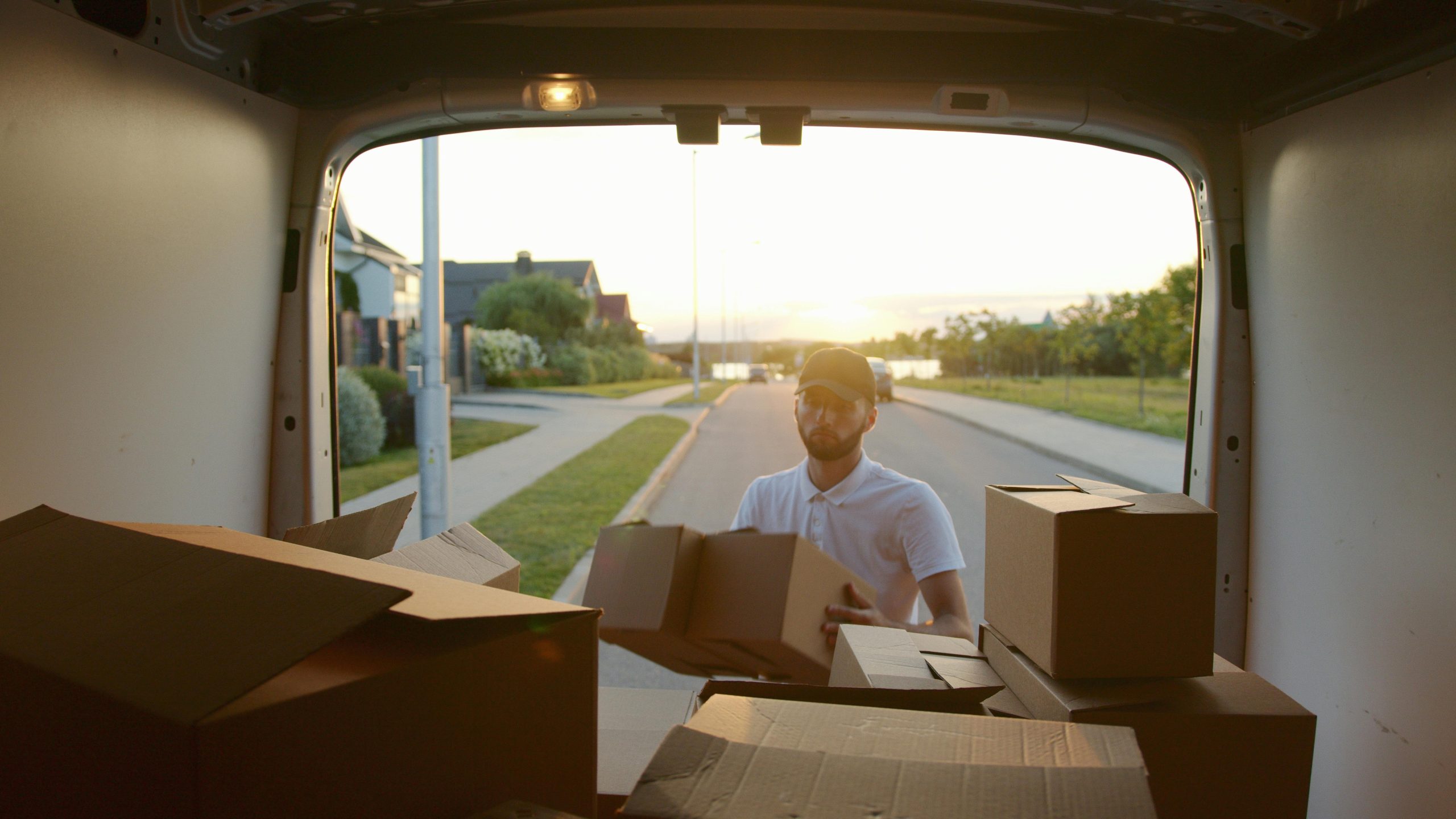 Man placing boxes in a moving van 