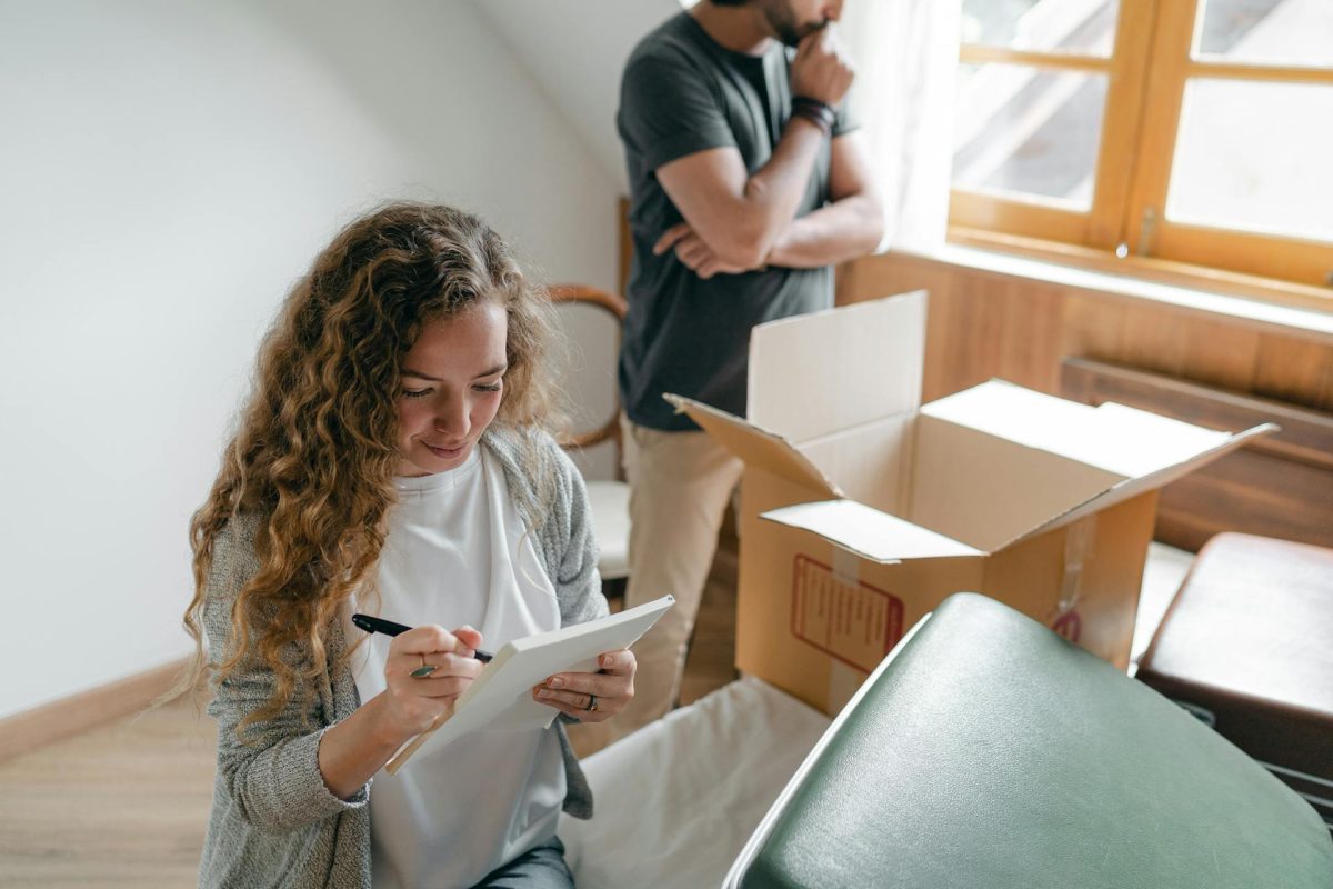 Man and woman checking a list surrounding around boxes