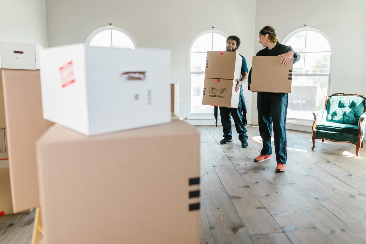 Two movers moving boxes in a home