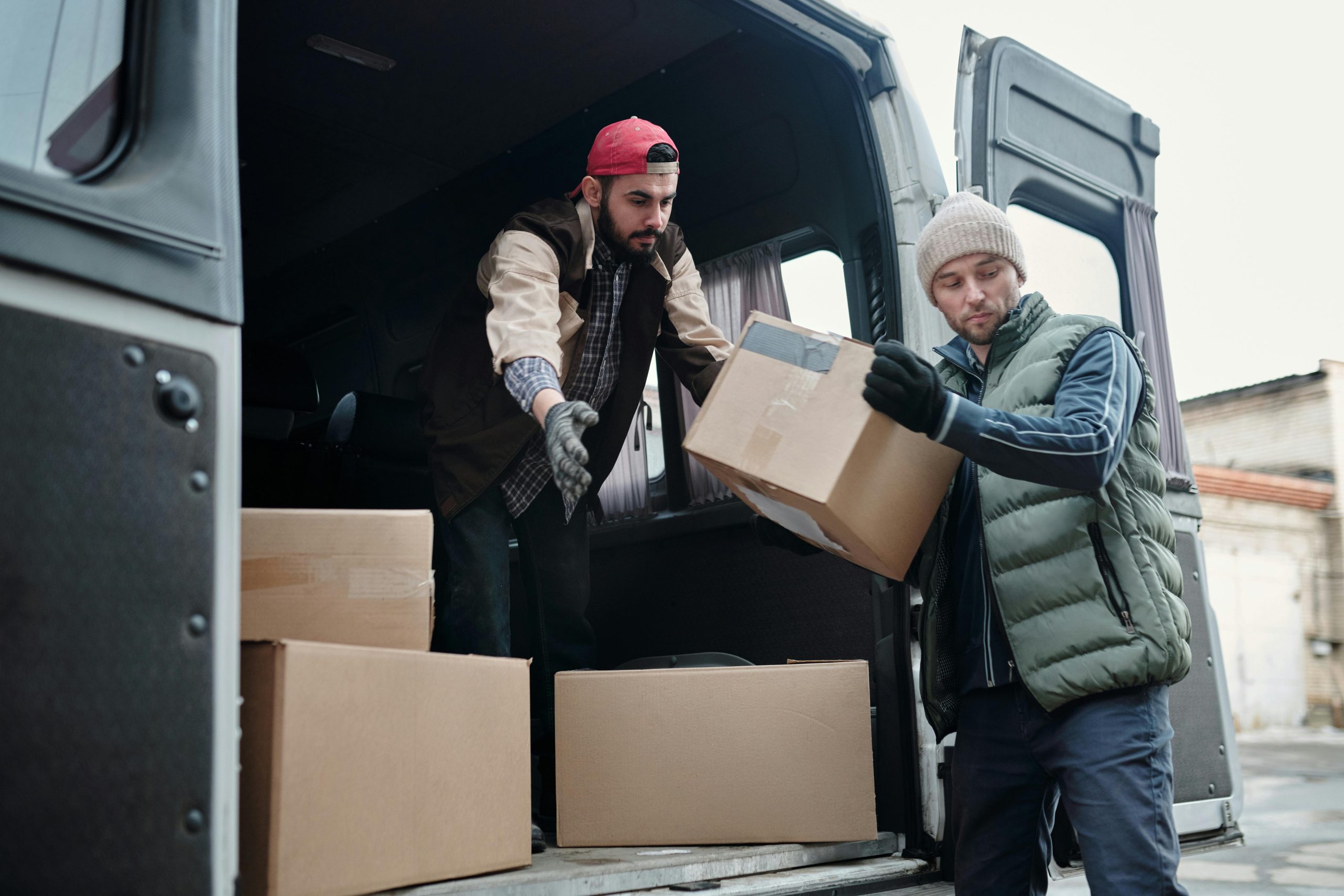 Two men taking boxes out of a moving truck
