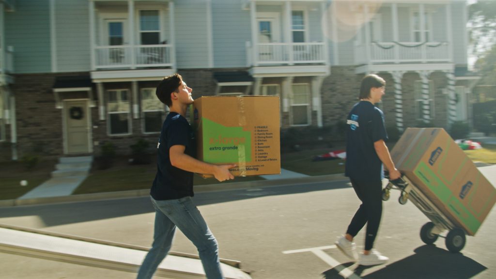 UniMovers' college movers unloading a moving truck with a dolly